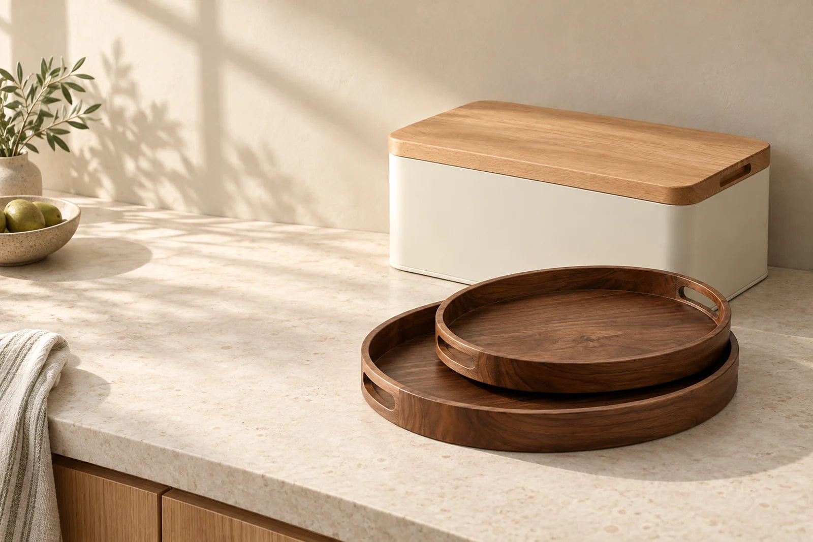A calm kitchen corner with a bread box and walnut serving trays